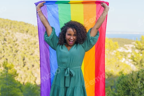 Preview: Excited Woman Holds Rainbow Flag Outdoors
