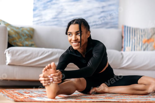 Preview: Sporty and flexible pretty African-American girl dressed in sportswear, is engaged fitness