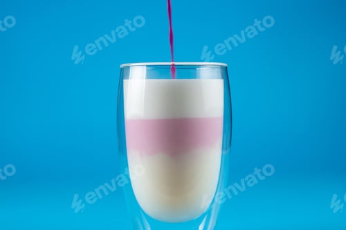 Preview: Pink pitahaya matcha in double glass on blue surface, tropical cocktail.