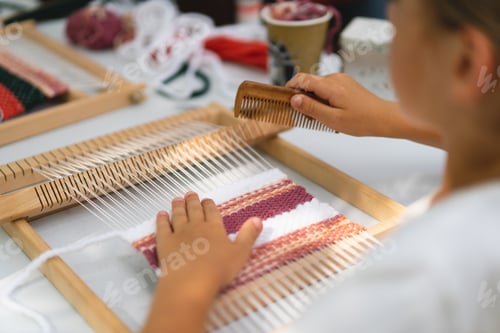 Preview: Girl weaving small rug with pattern at masterclass on weaving.