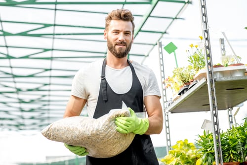 Preview: Handsome gardener with bag of soil