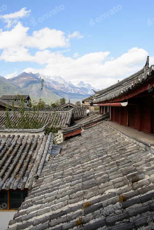 Preview: Village rooftops under blue sky and mountains on horizon