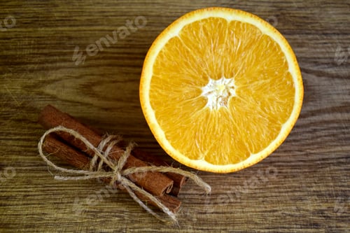 Preview: Fresh orange and Cinnamon sticks on wooden background. Spices and sliced orange on wooden table.