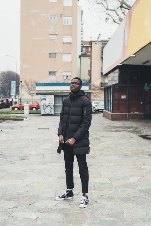 Preview: portrait of young african man standing in the street and looking camera