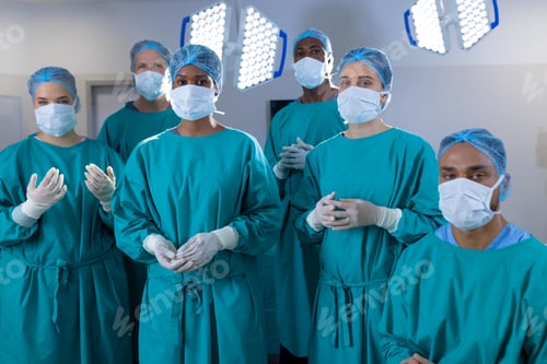 Preview: Portrait of diverse surgeons wearing surgical gowns in operating theatre at hospital