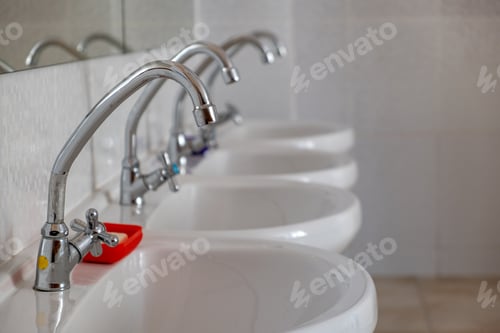 Preview: White ceramic washing basins with shiny stainless steel water tap.