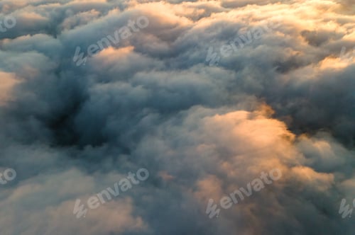 Preview: Aerial view over surface of white dense clouds at sunset.