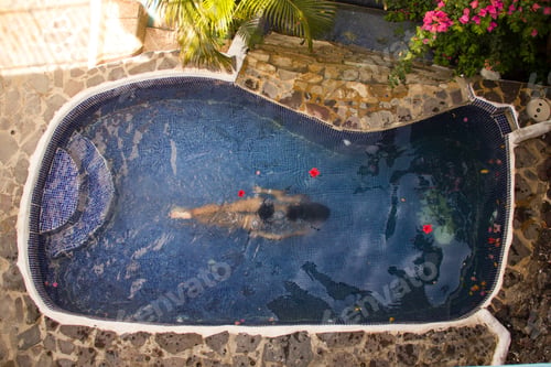 Woman Floating Peacefully in Tropical Swimming Pool