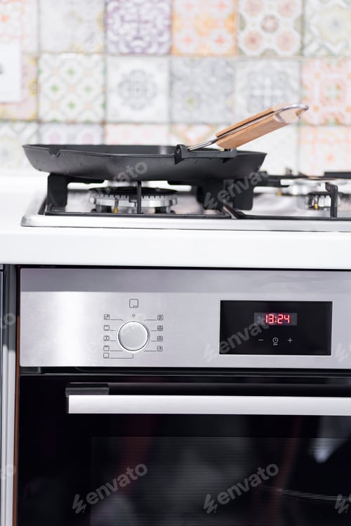 Preview: Empty frying grill pan on a gas stove on the background of the oven. Kitchen interier