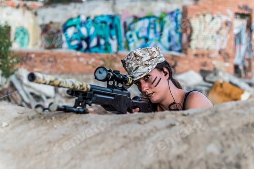 Preview: Attractive female holding a gun and aiming it captured in the middle of a forest