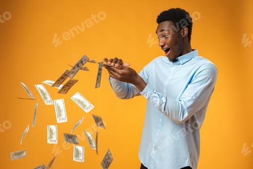 Preview: Excited black guy holding stack of Dollars in yellow studio