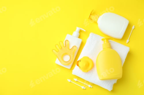 Preview: Different baby hygiene accessories on yellow background