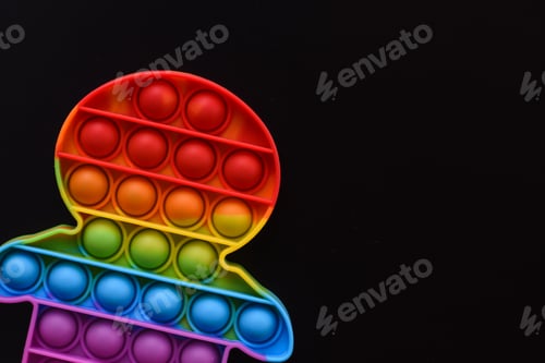 Preview: colorful anti stress pop it toy on black background.