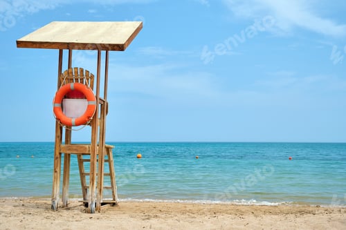 Preview: Emplty wooden lifeguard station on sandy beach on ocean shore in summer