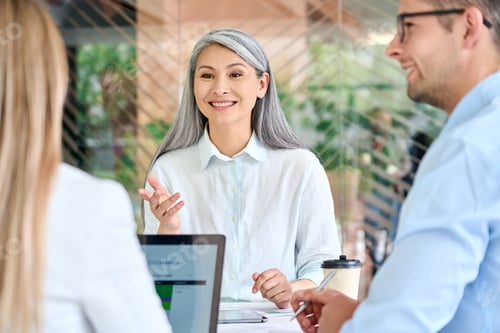 Preview: Older mature Asian manager talking to group of younger colleagues interns.