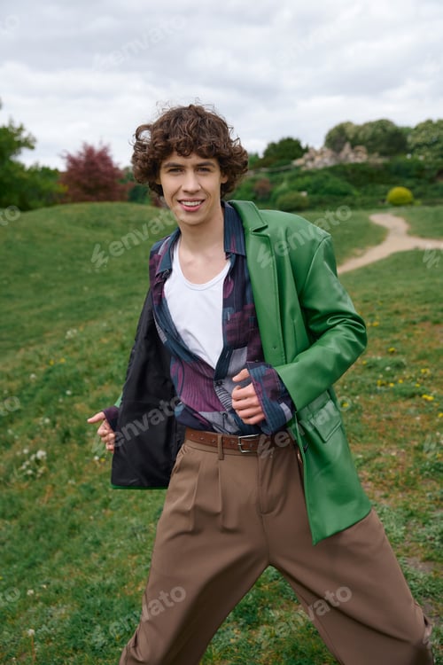Preview: Young man enjoys a relaxed walk in nature showcasing fashion sense and carefree attitude