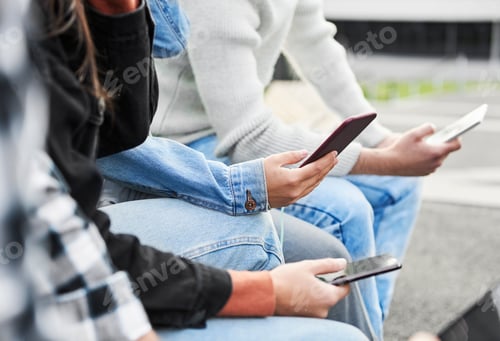 Preview: Close up of friends holding modern mobile phone in hands