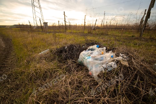 Preview: Plastic pollution on an Italian field. Abandoned plastic trash next to an irrigation canal