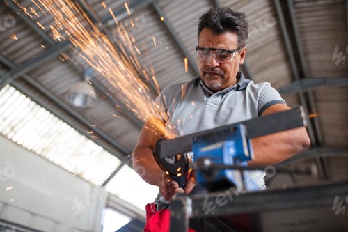 Preview: Mechanic using angle grinder in car workshop