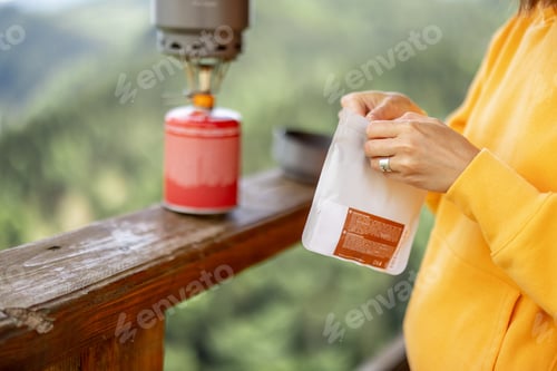 Preview: Woman prepares freeze-dried food for hiking in mountains