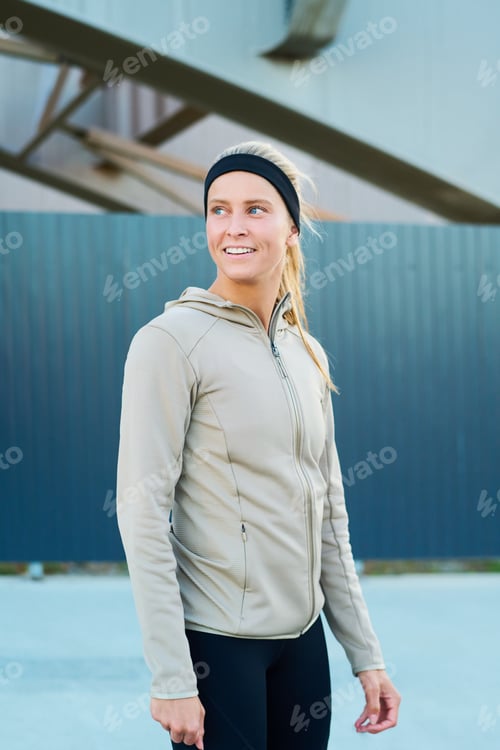 Preview: Happy young blond sportswoman in grey sport jacket and black leggins