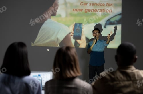 Preview: Young Chinese businessman speaking in microphone in front of audience