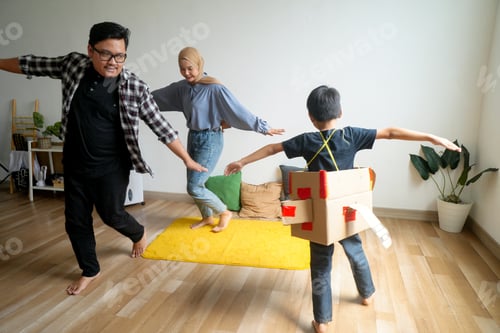 Preview: Dad, Mom And Son On Cardboard Box Airplane Playing Fly Together At Home