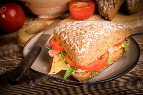 Preview: Triangular sandwich with cheese, ham and tomato.