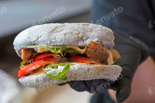 Preview: Chef holding burger in hand close up