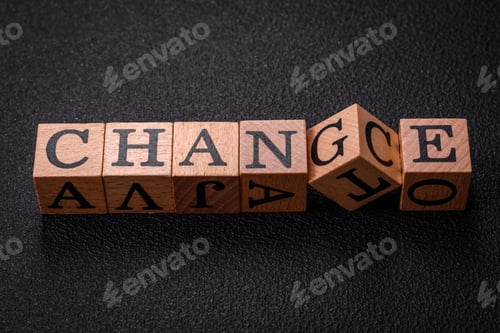 Preview: The inscription chance or change with wooden cubes on a dark concrete background