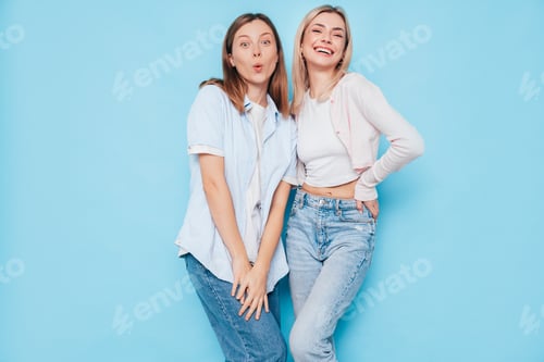 Preview: Two Young Women Laughing and Posing on Blue