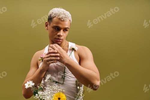 Preview: Young African American man flaunts trendy style with flowers in studio setting