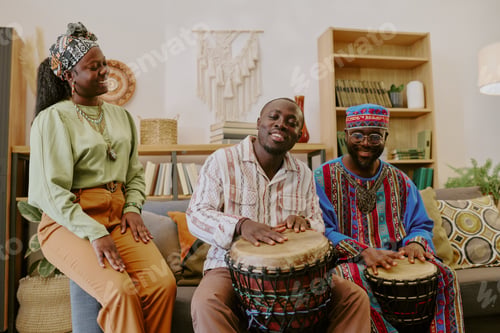 Preview: Black Young Adults Celebrating Kwanzaa by Playing Drums and Smiling Indoors