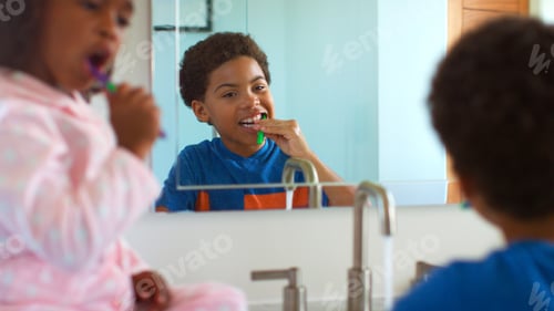 Preview: Brother And Sister Brushing Teeth Reflected In Bathroom Mirror At Home