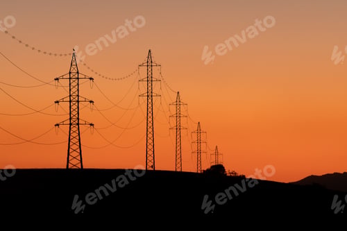 Preview: Towers of electricity over mountains at sunset