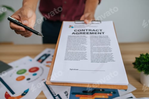 Preview: A male employee handed a file and a pen to another employee.