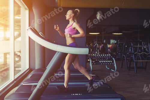 Preview: Fitness girl running on treadmill