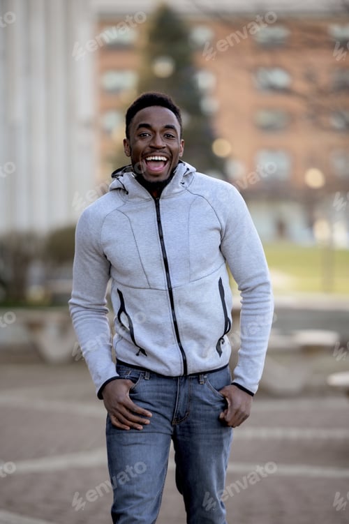Preview: Portrait of a smiling African-American man in a park under sunlight with a blurry background