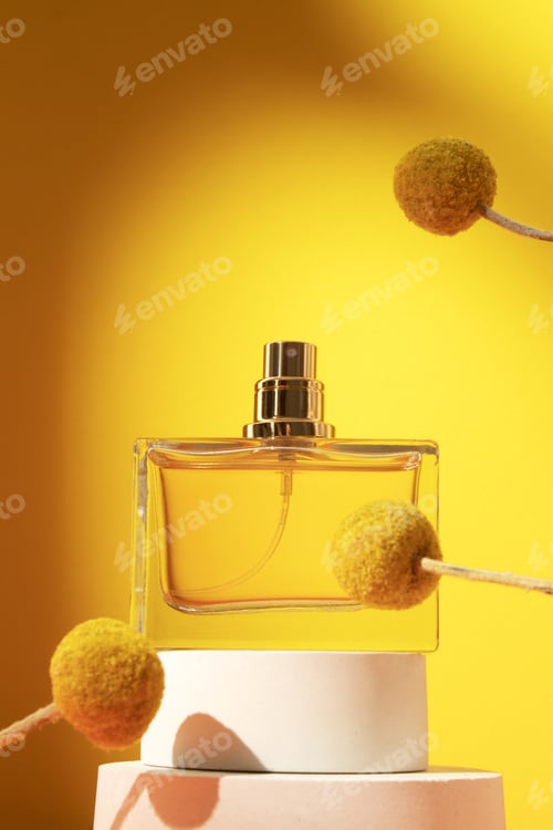 Preview: Perfume bottle with craspedia flowers. Concept of expensive perfume and cosmetics.
