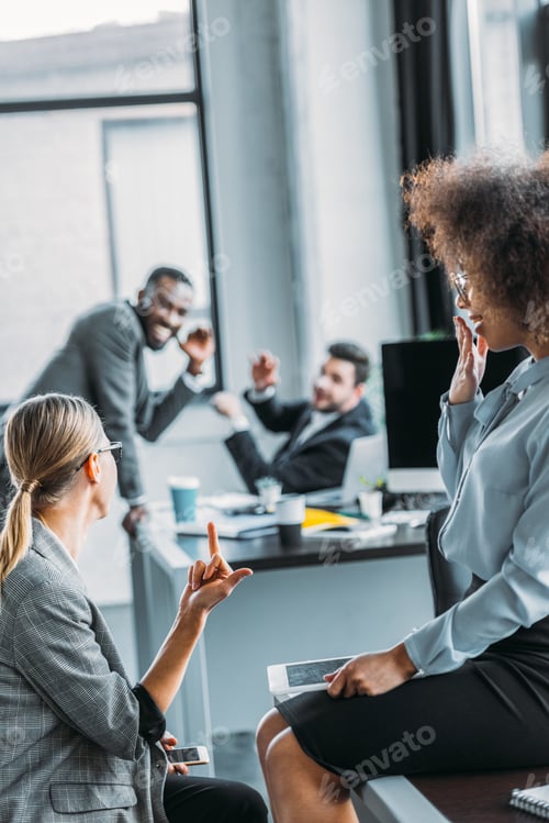 Preview: businesswoman showing middle finger to colleagues in office