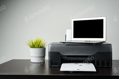Preview: Modern printer with paper and laptop on table in office