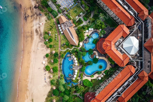 Preview: Aerial view of a symmetrical building of a resort surrounded by lush vegetation nearby body of water