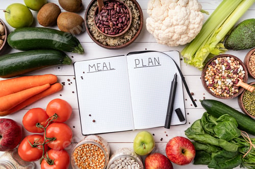 Preview: Weight lose and dieting concept. Notepad with words meal plan with healthy food, top view flat lay