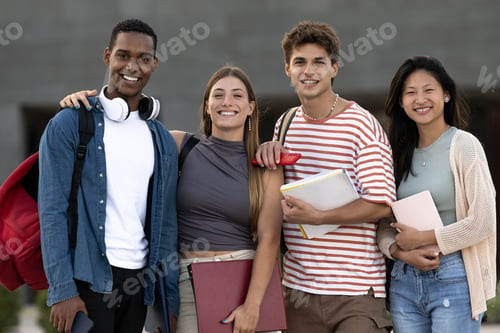 Preview: Diverse group of friends standing in the street with folder looking at camera. Multiracial young