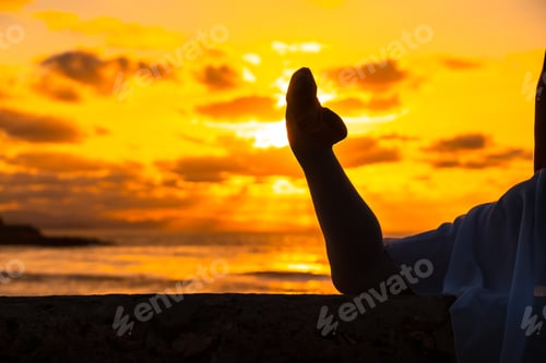 Preview: Young dancer next to the beach at sunset doing spagata with the sea in the background