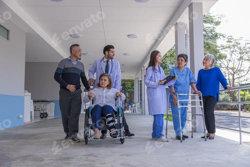 Preview: Doctors and nurse in hospital corridor with senior female and senior male patient in walker