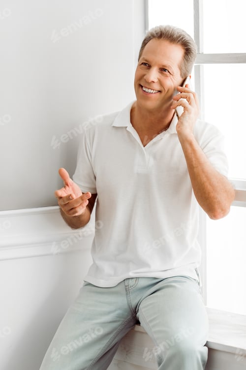 Preview: Smiling Man in White Shirt Talking on Phone