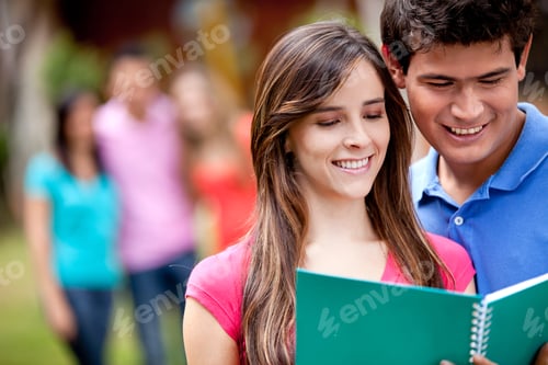 Preview: Couple Of Students With A Notebook Outdoors