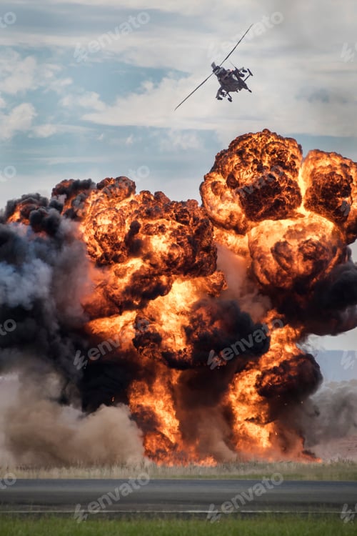 Preview: Vertical shot of an attack helicopter flying over an explosion