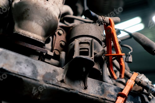 Preview: service station table there is elongated engine in which two tubes are clamped with orange tongs